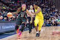 With a referee behind and between them, a basketball player in dark blue dribbling a ball moves forward, guarded by a player wearing yellow